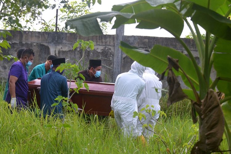 Petugas medis bersama warga mengangkat peti berisi jenazah pasien positif COVID-19 saat pemakaman di salah satu lokasi dalam wilayah Kabupaten Aceh Besar, Aceh, Rabu (17/6/2020). Gugus Tugas Percepatan Penanganan COVID-19 Aceh menyatakan hingga saat ini kasus positif COVID-19 sebanyak 37 orang, 15 orang di antaranya dalam perawatan, 20 orang sembuh dan dan dua orang meninggal. ANTARA FOTO/Ampelsa/foc.