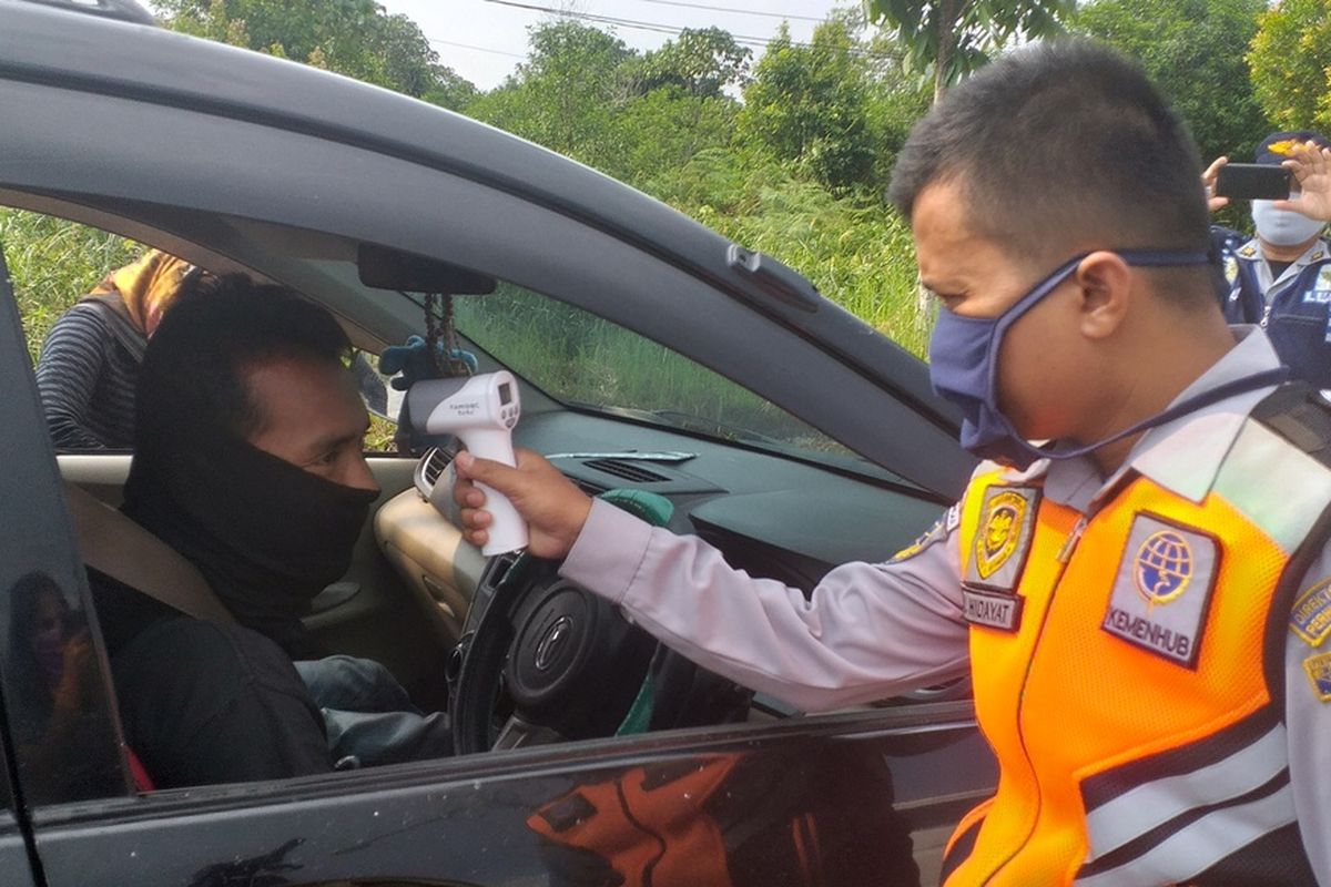 Pemeriksaan suhu tubuh pengendara yang hendak masuk ke Kota Pekanbaru di perbatasan Pekanbaru-Kampar, dalam masa PSBB untuk mencegah penyebaran Covid-19, Minggu (19/4/2020).