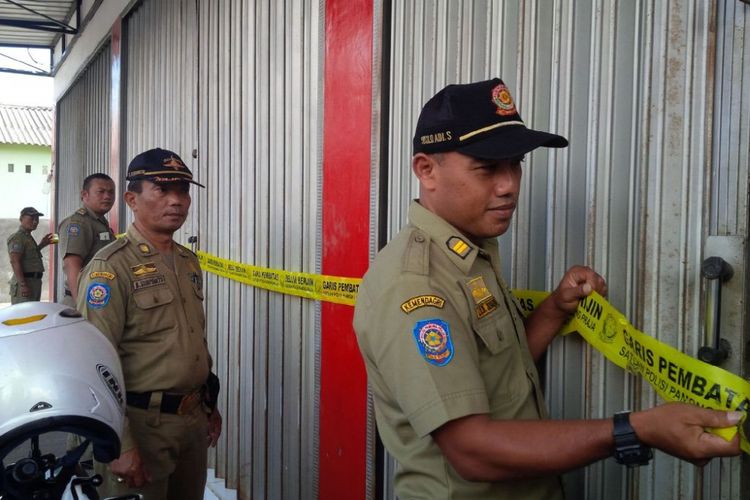 Petugas Satpol PP menyegel swalayan Alfamart di Jl Hasan Munadi No 9 RT 5 RW 7 desa Nyatnyono,   Kecamatan Ungaran Barat, Kabupaten Semarang, Rabu (19/7/2019) siang.