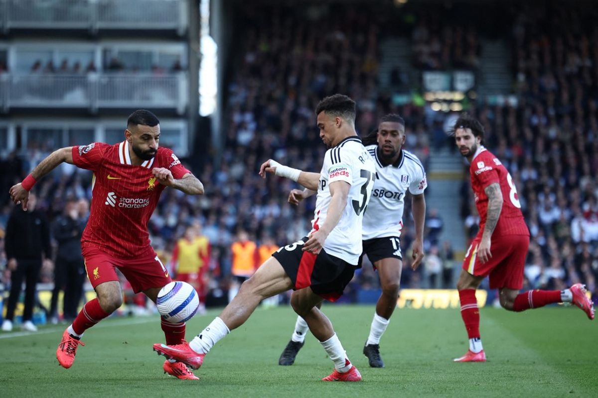 Mohamed Salah (kiri) dibayangi oleh Antonee Robinson dalam pertandingan Liga Inggris antara Fulham vs Liverpool di Craven Cottage di London pada 6 April 2025. (Photo by HENRY NICHOLLS / AFP)