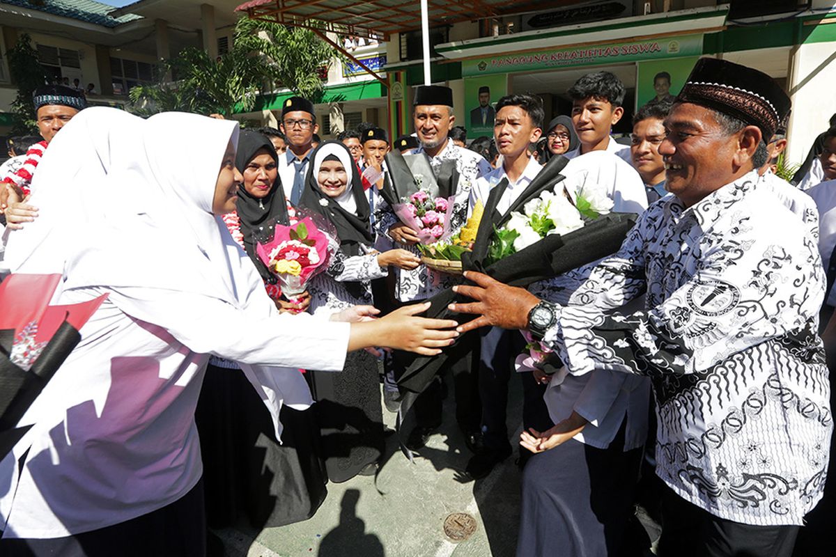 Pelajar memberikan bunga pada gurunya seusai upacara peringatan hari guru nasional dan dan HUT Persatuan Guru Republik Indonesia (PGRI) di MTsN Model, Banda Aceh, Aceh, Senin (25/11/2019). Peringatan hari guru nasional yang bertepatan dengan HUT ke-74 PGRI menjadi momentum memberikan penghargaan dan ungkapan terima kasih kepada guru yang telah mendidik serta meningkatkan kualitas sumber daya manusia generasi penerus pembangunan bangsa.