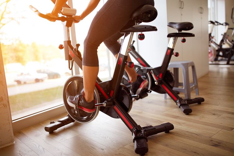 Ilustrasi menggunakan sepeda statis di tempat gym.