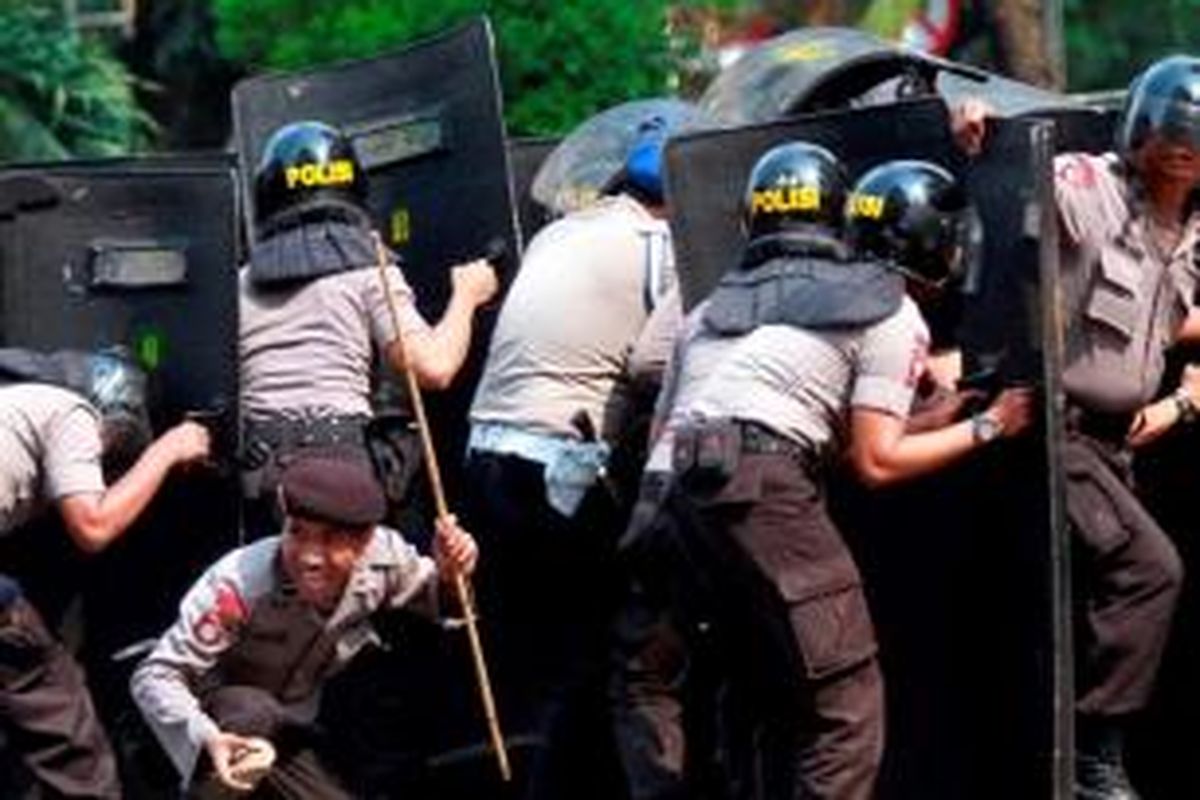 Polisi menghadapi massa Front Pembela Islam (FPI) yang melemparkan batu ke arah Gedung DPRD DKI Jakarta saat terjadi kerusuhan unjuk rasa FPI, Jumat (3/10/2014). Massa FPI berdemo menolak Ahok diangkat menjadi Gubernur DKI Jakarta.