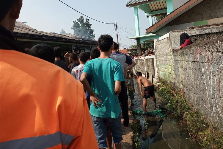 Sejumlah warga berupaya memadamkan api menggunakan air got, sejam kemudian Damkar Kabupaten Bogor berhasil menjinakkan api di tiga rumah tersebut, Kelurahan Nanggewer, Kecamatan Cibinong, Kabupaten Bogor, Senin (5/8/2019).