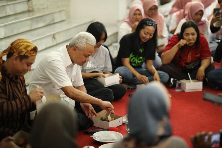 Gubernur Jawa Tengah Ganjar Pranowo menikmati tumpeng dan duduk bersama warga yang datang ke rumah dinasnya, Minggu (3/9/2023).
