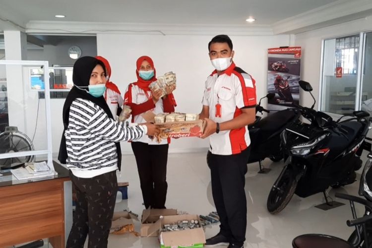 Yana (40), menyerahkan uang koin dan sejumlah uang kertas pecahan ribuan kepada petugas dealer untuk membeli kontan satu unit sepeda motor matik, di Kelurahan Sungai Beringin, Kecamatan Tembilahan, Kabupaten Inhil, Riau, Rabu (14/4/2021).