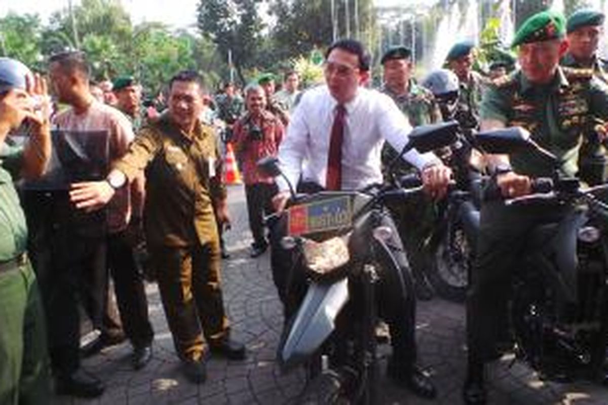 Gubernur DKI Jakarta Basuki Tjahaja Purnama menaiki motor Kawasaki Kawasaki D-Tracker 250 CC yang dihibahkan DKI kepada Kodam Jaya, di Balai Kota, Jumat (7/8/2015). 