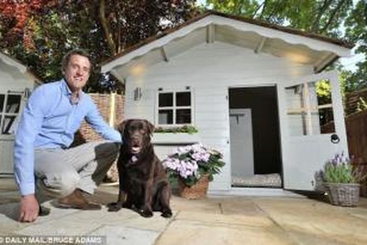 Tom Rawstorne dan anjing labrador coklatnya, Dolly (5), mencoba rumah anjing istimewa yang dilengkapi dengan pemanas di bawah lantai dan pencahayaan canggih.