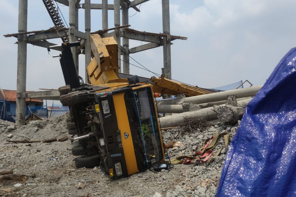 Truk pengangkut crane terguling di lokasi proyek PDAM di Jalan Mawar, Pancoran Mas, Depok, Jumat (15/10/2021). Warung dan rumah warga tertimpa dengan kerusakan cukup berat.