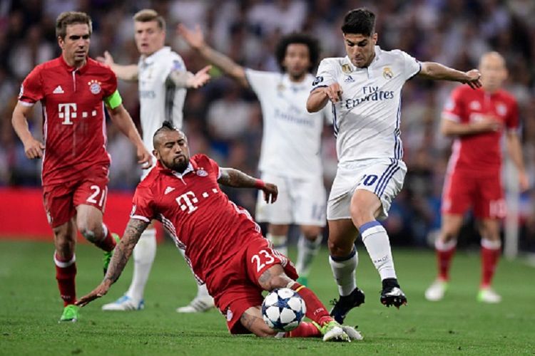 Arturo Vidal mencoba merebut bola dari Marco Asensio, sementara Philipp Lahm memerhatikannya dari belakang, saat Bayern Muenchen bertandang ke markas Real Madrid, Santiago Bernabeu, pada perempat final Liga Champions, Rabu (18/4/2017). 