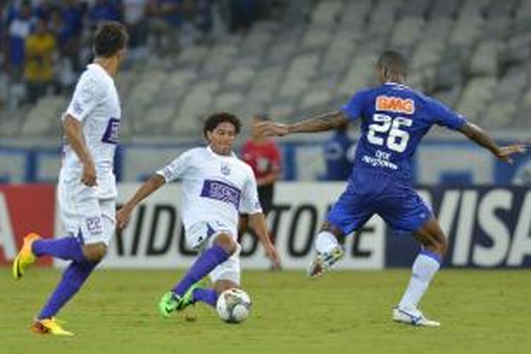 Bek Cruzeiro, Dede (kanan), mengawal penyerang Defensor Sporting, Felipe Gedoz (tengah), pada pertandingan Copa Libertadores, di Stadion Mineirao, Belo Horizonte, 20 Maret 2014.