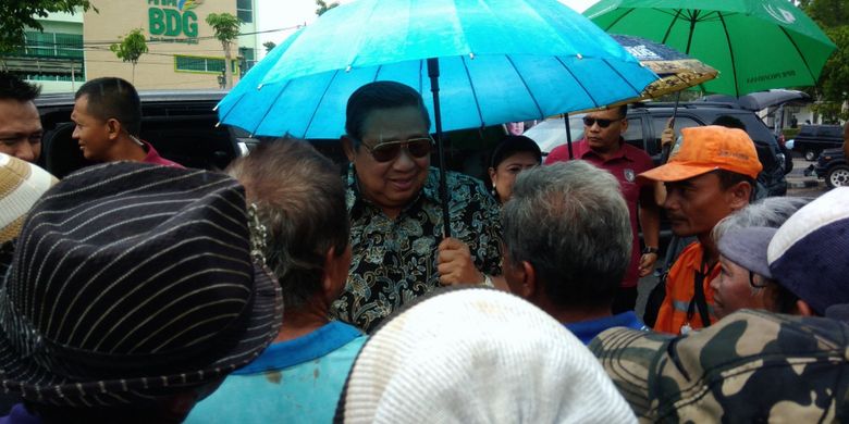 Presiden Keenam RI, Susilo Bambang Yudhoyono (memegang payung) menyapa warga di Taman Parkir Wonosari, Gunungkidul, DI Yogyakarta, Senin (10/12/2018).