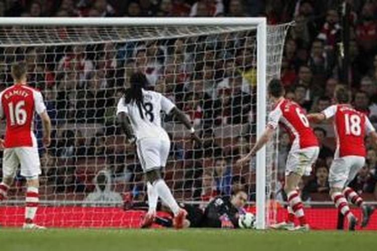 Striker Swansea City, Bafetimbi Gomis (baju putih), mencetak gol kemenangan ke gawang Arsenal pada laga Premier League di Stadion Emirates, London, Senin (11/5/2015) waktu setempat.