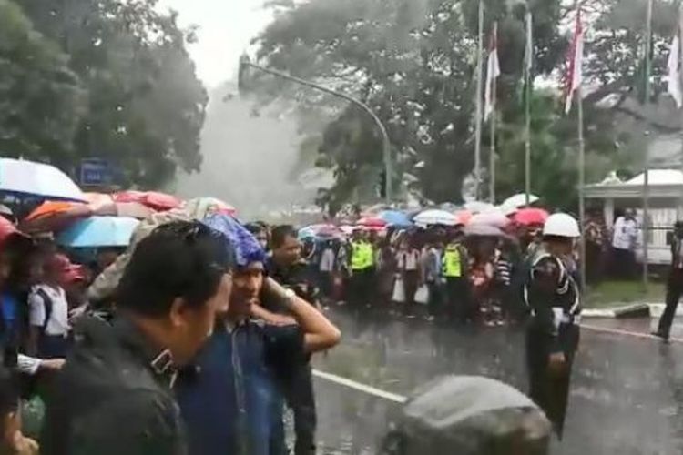 Hujan deras mengguyur Bogor saat Raja Arab Saudi Salman bin Abdulaziz al-Saud tiba di Istana Bogor, Rabu (1/3/2017) siang. Meski hujan mengguyur, warga tetap setia menunggu dengan mengandalkan payung dan jas hujan.
