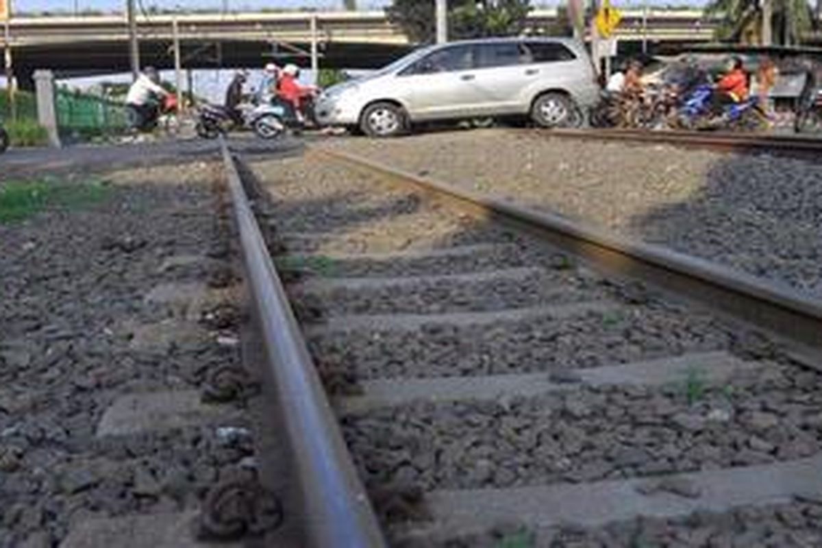 Kendaraan melintasi perllintasan kereta api yang tidak dilengkapi palang pintu di dekat Stasiun Rawa Buaya, Jakarta, Jumat (3/5/2013). Tidak adanya palang pintu menjadikan perllintasan kereta api di kawasan tersebut rawan kecelakaan.