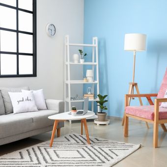 Ilustrasi ruang tamu dengan dinding aksen warna biru. 