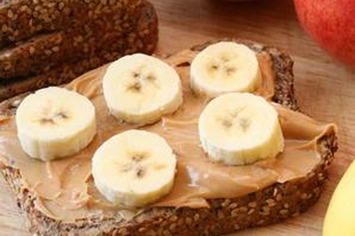 Roti gandum dengan selai kacang dan irisan pisang, pilihan sehat untuk menambah energi.
