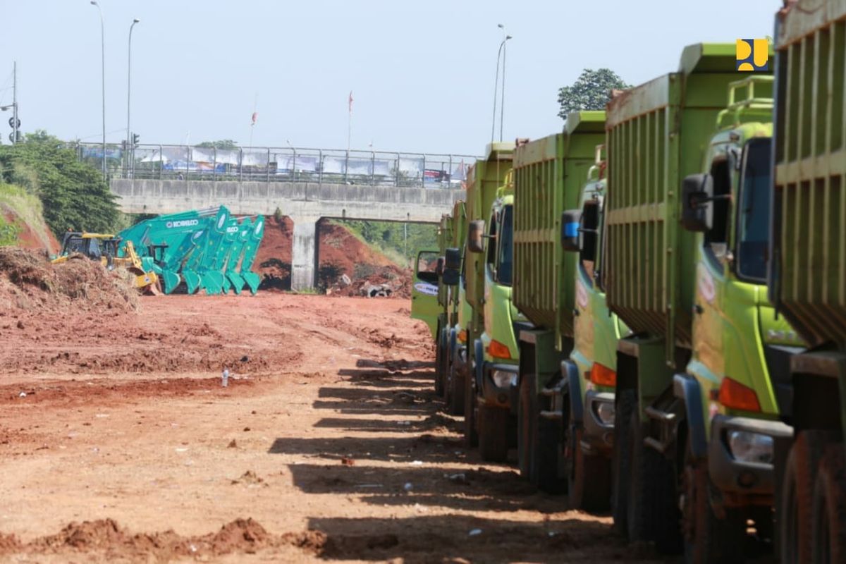 Truk-truk pengangkut tanah terparkir di sekitar area pembangunan Tol Cijago Seksi 3.