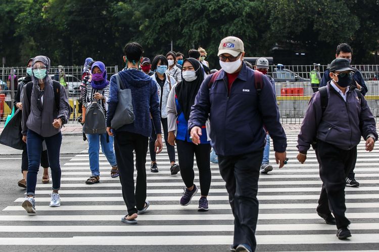 Pekerja yang menggunakan masker saat menyebrangi zebra cross di Jalan M.H Thamrin, Jakarta Pusat, Senin (14/9/2020). PSBB kembali diterapkan tanggal 14 September 2020, berbagai aktivitas kembali dibatasi yakni aktivitas perkantoran, usaha, transportasi, hingga fasilitas umum.