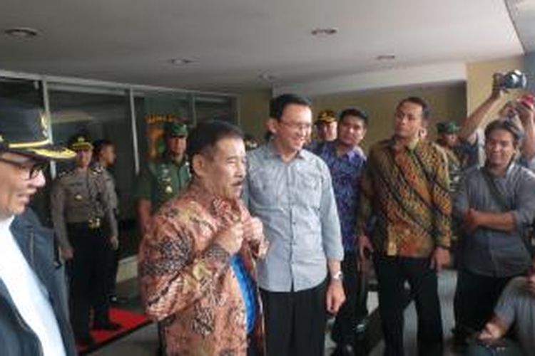 Gubernur DKI Jakarta Basuki Tjahaja Purnama saat memberikan batik kepada Manajer Persib Bandung Umuh Muchtar, di Mapolda Metro Jaya, Minggu (18/10/2015).