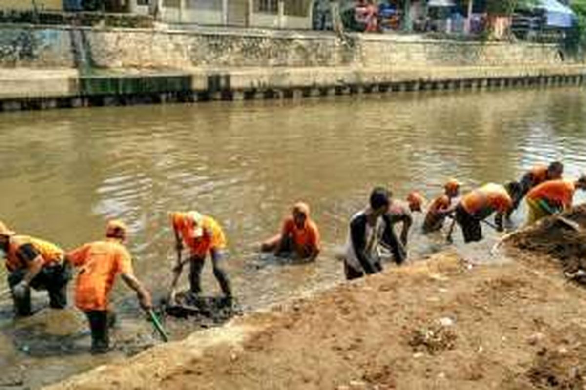 Petugas PPSU dan PHB Sudin Kebersihan bahu-membahu membersihkan lumpur di Kali Ciliwung belakang Kantor Kelurahan Kwitang, Senen, Jakarta Pusat, Selasa (17/5/2016).