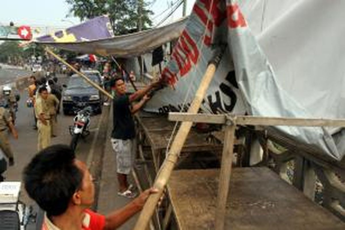 Pedagang kaki lima (PKL) membongkar dan memindahkan barang dagangannya saat petugas Satpol PP menertibkan mereka di Pasar Mainan Gembrong, Jakarta Timur, Rabu (14/8/2013). Petugas Satpol PP dibantu Polisi dan TNI menertibkan sepanjang Jalan Jatinegara hingga Stasiun dan Pasar Gembrong dari PKL yang membuka lapak hingga badan jalan yang menyebabkan kemacetan.