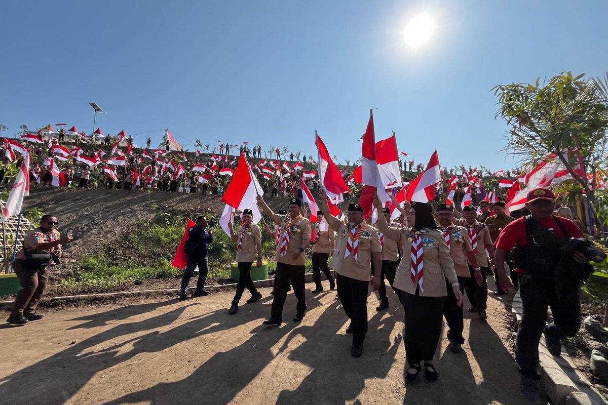 KIBARKAN BENDERA—Wali Kota Madiun, Maidi bersama ribuan anak mengibarkan bendera merah putih memperingati Hari Pramuka dan HUT RI Ke-80 di bukit TPA Sampah Winongo, Kota Madiun, Jawa Timur, Jumat (15/8/2025).