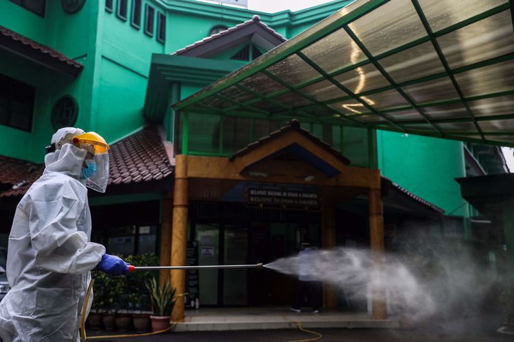 Petugas Palang Merah Indonesia (PMI) Jakarta Pusat menyemprotkan cairan disinfektan di sekolah SMAN 4, Jalan Batu, Gambir, Jakarta Pusat, Selasa (23/6/2020). Palang Merah Indonesia mengencarkan penyemprotan cairan disinfektan di sekolah di tengah masa penerimaan peserta didik baru (PPDB) tahun ajaran 2020/2021.