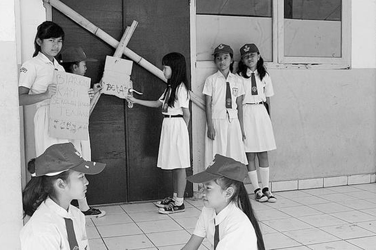 Siswa Sekolah Dasar Negeri 1 Leuwinanggung, Kota Depok, Jawa Barat,  berada di luar ruang kelas yang dipalangi bilah bambu, Senin (18/6). Sekelompok orang yang mengaku berhak atas tanah sekolah itu menyegel dan menghentikan kegiatan sekolah. Setidaknya ada empat sekolah yang terancam tutup karena sengketa tanah.