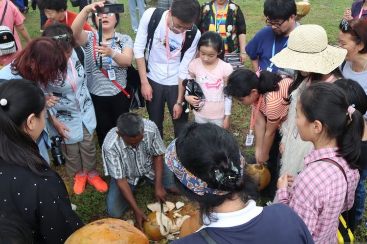 Wisatawan asal Kunming, Provinsi Yunnan, China berebut mendapatkan kelapa muda yang disuguhkan di STIB Pariaman, Sumatera Barat.