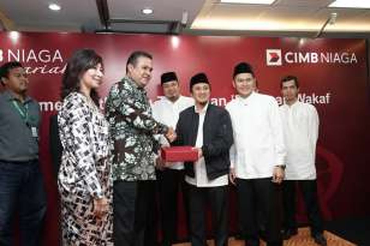 Direktur Syariah Banking CIMB Niaga Pandji P. Djajanegara (ketiga dari kiri) menyerahkan cenderamata kepada Pembina Yayasan PPPA Daarul Quran Ustad Yusuf Manshur (ketiga dari kanan) disaksikan Head of Sales and Distribution Syariah Banking CIMB Niaga Diah R. Paramaiswari (kedua dari kiri) dan sejumlah pimpinan lembaga wakaf  di sela acara customer gathering Tabungan iB Mapan Wakaf di Jakarta, Selasa (13/12). 