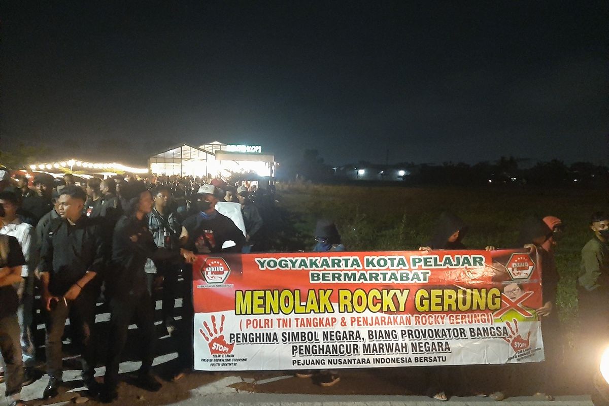 Massa membentangkan spanduk menolak kehadiran Rocky Gerung menjadi pembicara yang digelar di Bento Kopi, Sleman.