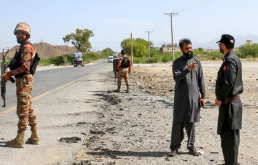 Petugas keamanan berjaga di lokasi pengeboman bus sekolah di distrik Khuzdar, provinsi Balochistan, Pakistan, Rabu (21/5/2025)