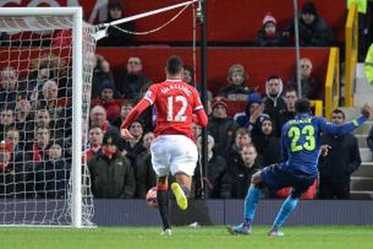 Penyerang Arsenal Danny Welbeck (kanan) melepaskan tembakan yang berujung gol pada pertandingan perempat final Piala FA melawan Manchester United, di Old Trafford, Senin (9/3/2015). Dengan gol tersebut, Welbeck Welbeck membuat mantan klubnya itu kalah 1-2.