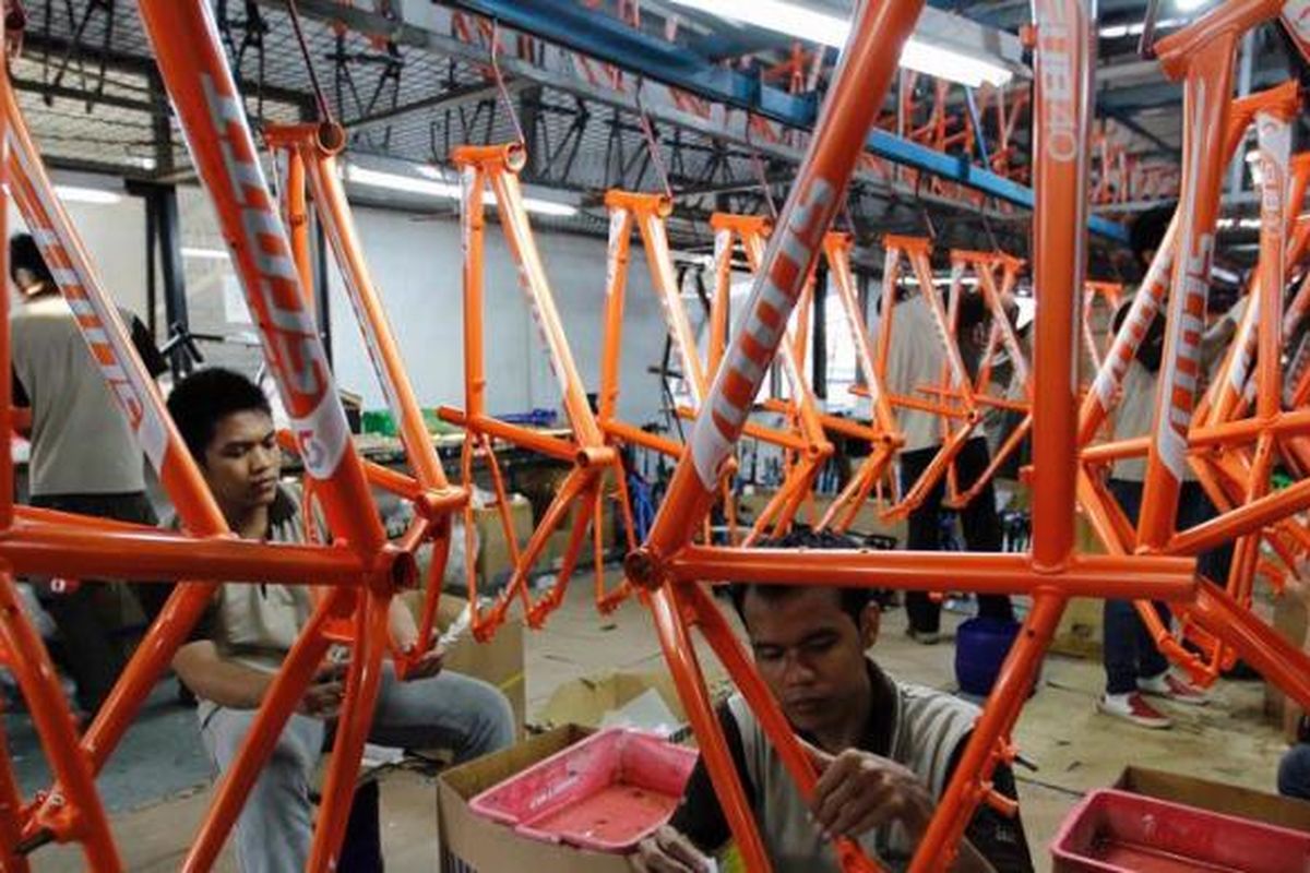 Pekerja memasang label di kerangka sepeda merek SCOTT di pabrik sepeda PT Insera Sena di Desa Wadungasih, Bunduran, Sidoarjo, Jawa Timur, beberapa waktu lalu.