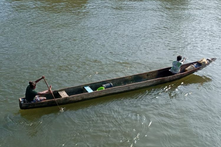 Dua orang nelayan, saat menayung melewati sungai ke laut di Kampung Poumako, Distrik Timika Timur, Kabupaten Mimika, Papua, Rabu (06/04/2022).