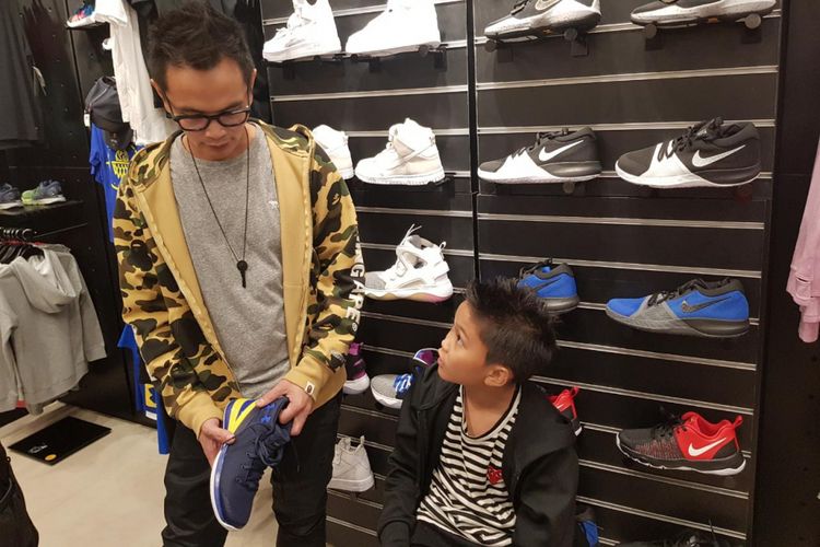 Anggota Project Pop, penyanyi Hermann Josis Mokalu atau Yosi menemani anaknya memilih sepatu.