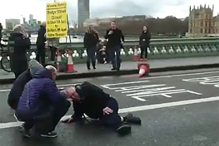 Gambar diambil dari potongan video yang diperoleh dari akun Twitter politisi dan wartawan Polandia, Radosaw Sikorski, menunjukkan seorang pria terduduk di jalanan yang tengah dibantu di Westminster Bridge, London, Inggris, Rabu (22/3/2017), menyusul terjadinya serangan teroris yang mengakibatkan 4 orang tewas dan puluhan terluka. 
