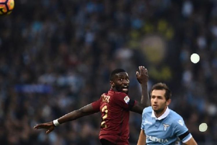 Antonio Rudiger (AS Roma) dan Senad Lulic (Lazio) bentrok dalam perebutan bola pada laga Derbi Roma di Stadion Olimpico, Minggu (4/12/2016). 