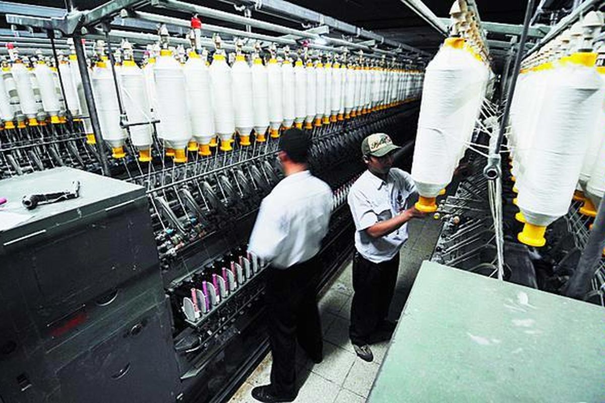 Karyawan PT Danliris Sukoharjo, Jawa Tengah, membersihkan mesin pemintal benang yang tidak beroperasi akibat pemadaman listrik secara bergilir, Senin (7/7).  