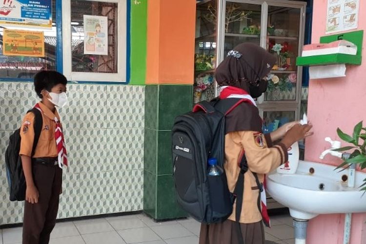 Sejumlah siswa SDN Kalinyamat Wetan 1 Kota Tegal antre cuci tangan sebelum masuk ruang kelas saat perdana mengikuti pembelajaran tatap muka (PTM) terbatas, Jumat (1/10/2021).