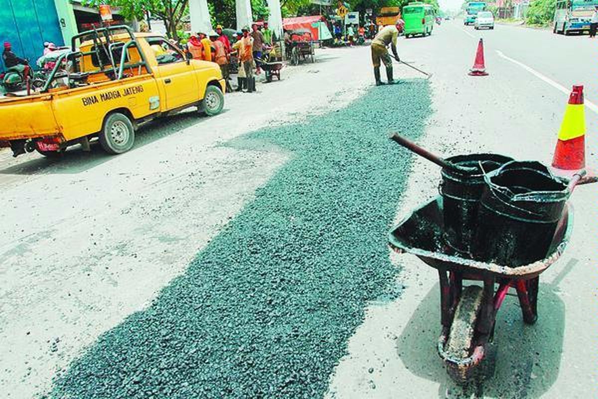 Pekerja menutup jalan berlubang dengan batu kerikil dan aspal di Jalan Raya Demak-Semarang Kilometer 9, Sayung, Demak, Jawa Tengah, Sabtu (15/3). Perbaikan jalan oleh Dinas Bina Marga Jawa Tengah secara tambal sulam tersebut dikhawatirkan tidak bertahan lama.  