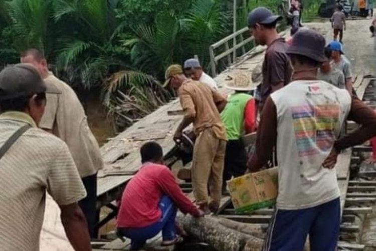 Warga secara swadaya memperbaiki jembatan Parit 16 yang rusak di Desa Pulau Kecil, Kecamatan Reteh, Kabupaten Inhil, Riau, Sabtu (23/10/2021).  