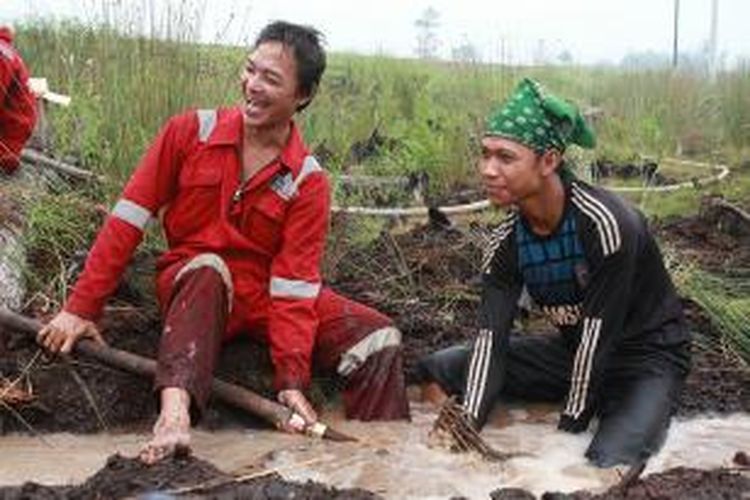 Hendra (kanan) saat bersama tim Sekolah Relawan membuat sumur bor disalah satu areal gambut yang terletak di Desa Tumbang Nusa, Kabupaten Pulang Pisau, Kalteng (30/10/2015) 