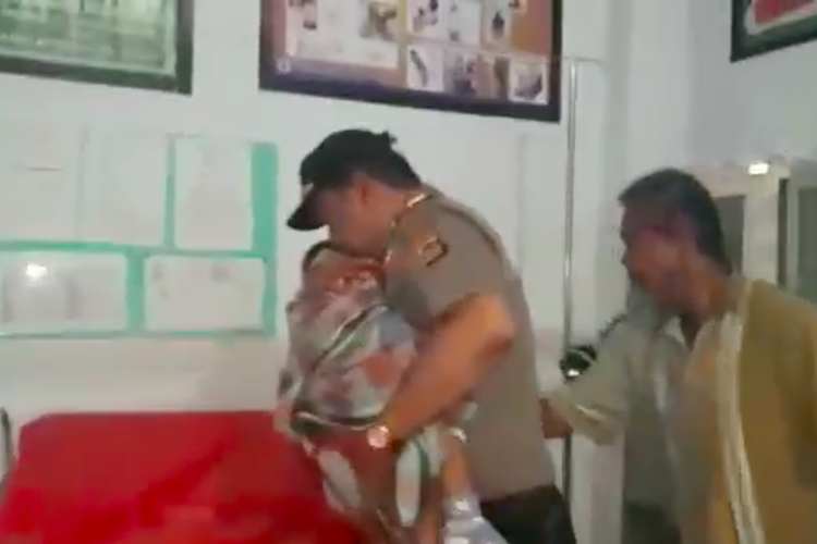 Seorang polisi di Baubau, Sulawesi Tenggara, menolong seorang bocah yang kejang-kejang.