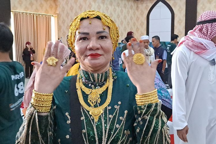 Suarnati Daeng Kanang (46) salah satu jemaah haji perempuan asal Embarkasi Makassar, Sulsel kloter 1 tampak nyentrik dan glamor dengan emas 180 gram di tubuhnya saat tiba di Asrama Haji Sudiang Makassar, Rabu (5/7/2023).
