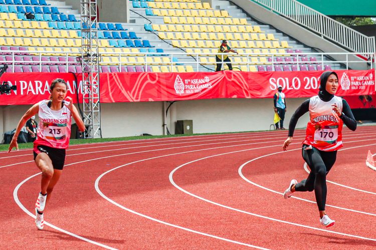 Atlet para atletik Indonesia, Putri Aulia (kanan), meraih medali emas ASEAN Para Games 2022 di Stadion Manahan, Solo, Selasa (2/8/2022). Putri Aulia mengalahkan rekannya, Ni Wayan Ayu Alvina (kiri) di nomor 200 meter T13.