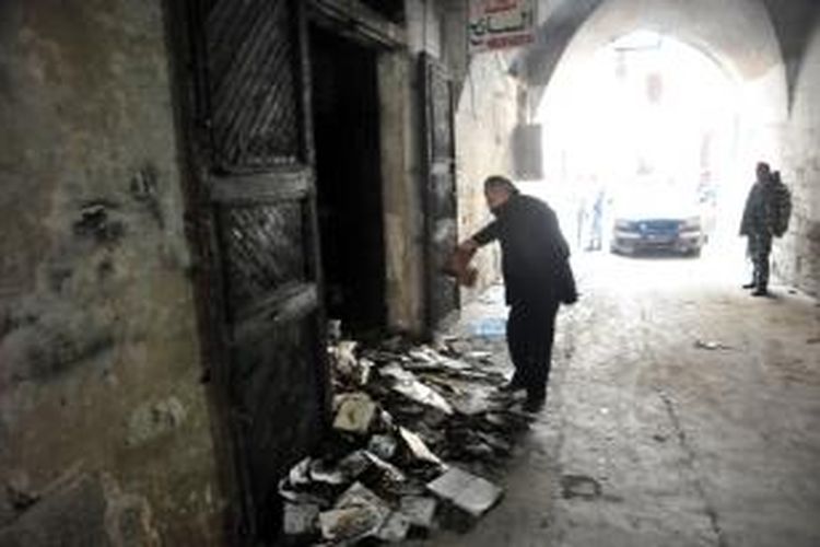 Seorang pria memperhatikan tumpukan buku yang hangus setelah sebuah perpustakaan milik seorang pendeta Gereja Ortodoks Yunani di kota Tripoli, Lebanon dibakar sekelompok orang.