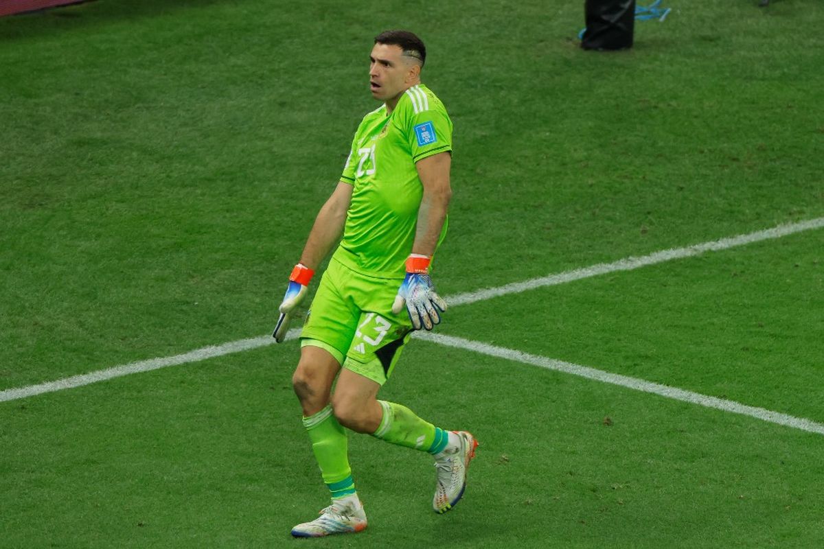 Emiliano Martinez menari usai melihat sepakan penalti Aurelian Tchouameni melebar dalam laga final Piala Dunia 2022 antara Argentina vs Perancis di Stadion Lusail, Doha, Qatar, 18 Desember 2022. Penampilan apik di Piala Dunia 2022 membuat Martinez masuk dalam daftar nominasi Kiper Terbaik FIFA 2022. (Photo by Odd ANDERSEN / AFP)