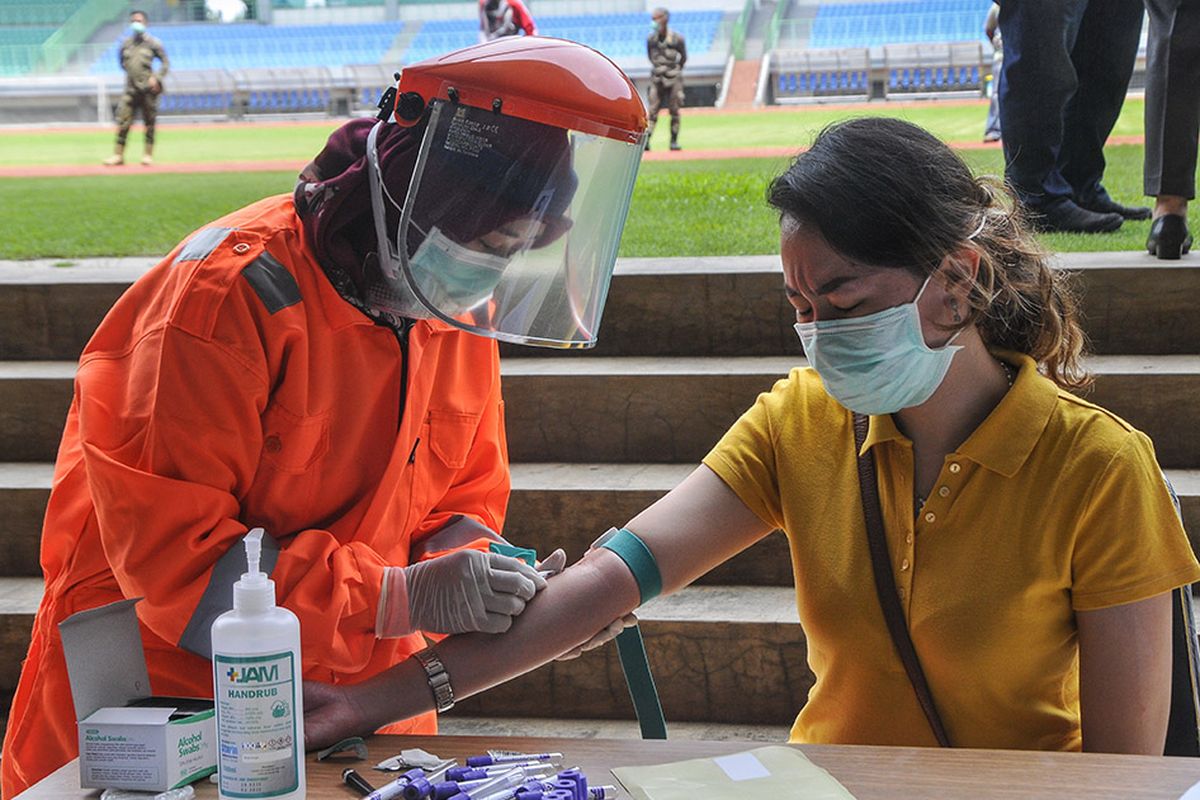 Petugas medis mengecek kesehatannya dengan mengambil sampel  darah dengan metode rapid test (pemeriksaan cepat) di Stadion Patriot Candrabhaga, Bekasi, Jawa Barat, Rabu (25/3/2020). Pemeriksaan yang dilakukan khusus tenaga medis di Bekasi guna memutus mata rantai penyebaran virus COVID-19.